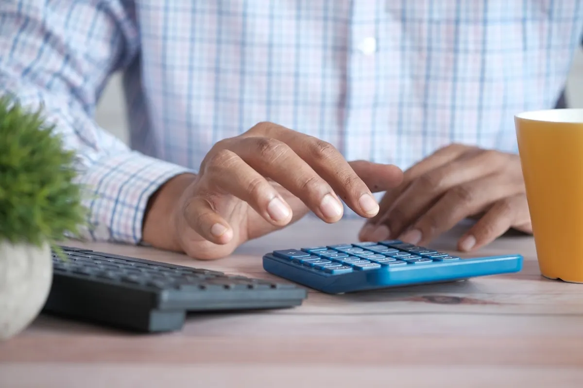 Calculator and paperwork for reviewing closing disclosure costs