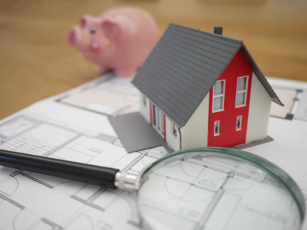 House model beside magnifying glass comparing title insurance policies